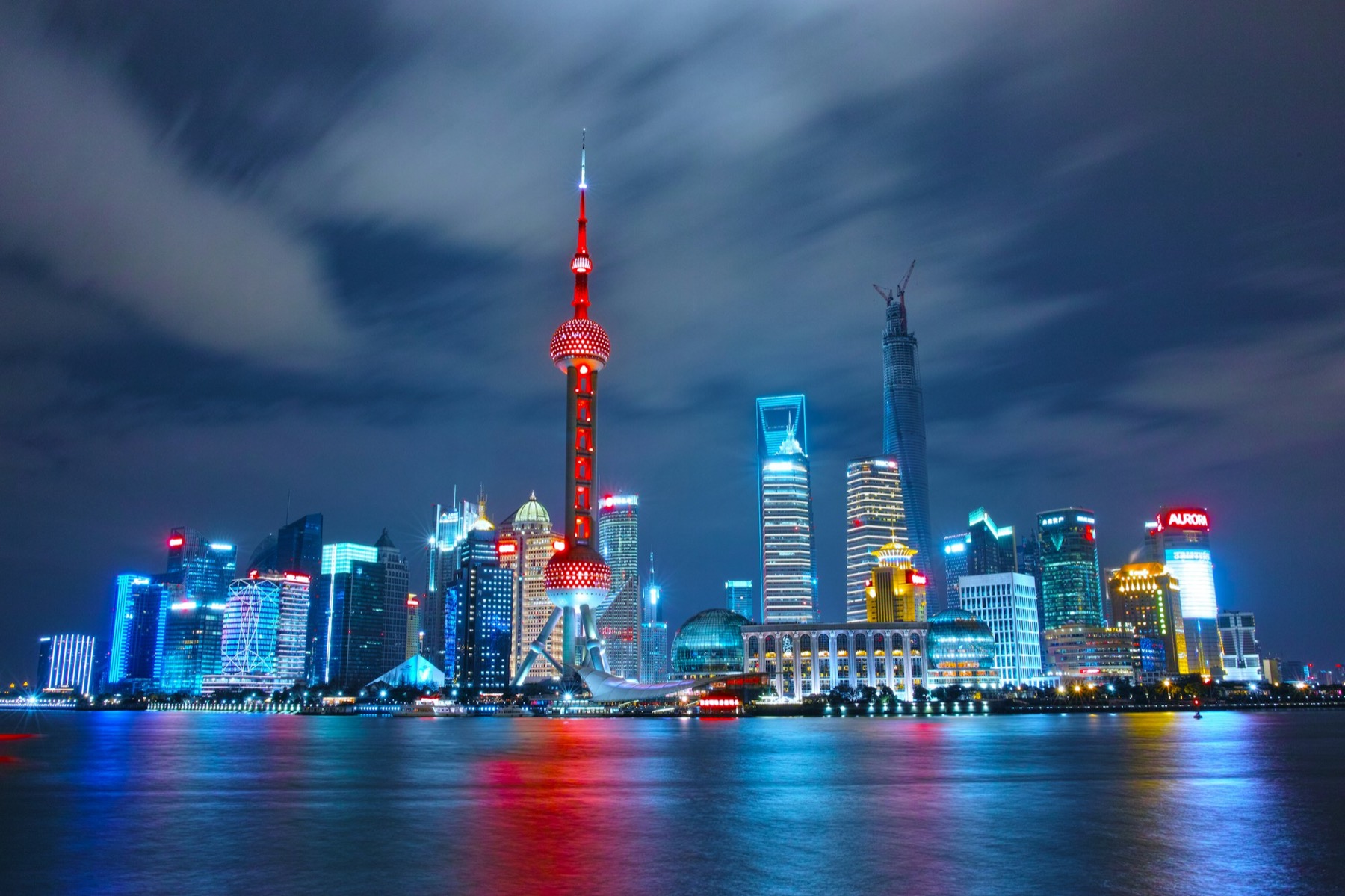 夜色中的上海外滩对岸，东方明珠与陆家嘴灯火倒映在黄浦江上